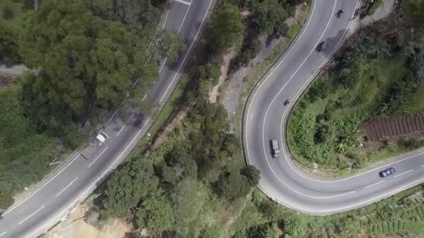 Steep serpentine with small cars passing rural houses — Stock Video