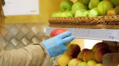 Bayan elinde steril eldivenle kivi tutan köpeğe bakıyor.