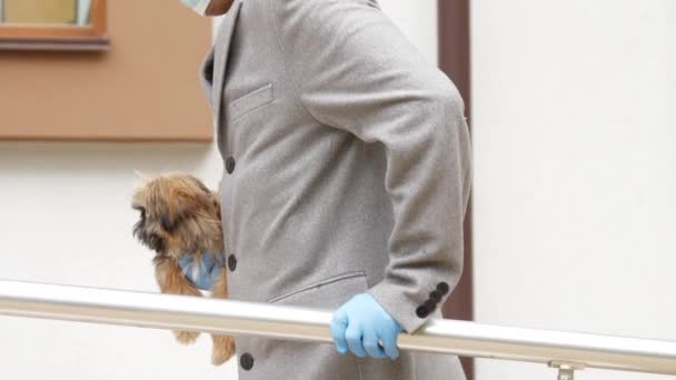 Ο τύπος με το χαλασμένο πόδι πηγαίνει στο νοσοκομείο κρατώντας ένα μικρό σκυλί. — Αρχείο Βίντεο