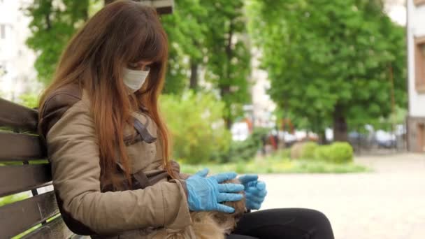 Lonely lady in disposable mask and gloves pets small dog — Stock Video