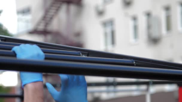 Person in sterile gloves exercises on black horizontal bar — Stock Footage Person in sterile gloves exercises on black horizontal bar Royalty Free Stock Video