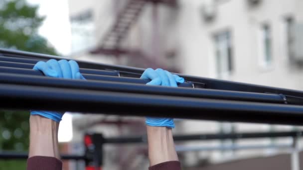 Persona en guantes estériles ejercicios en barra horizontal negro — Vídeos de Stock