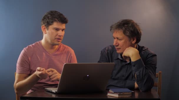 Guy legt uit hoe computerprogramma gebruiken om senior vader — Stockvideo