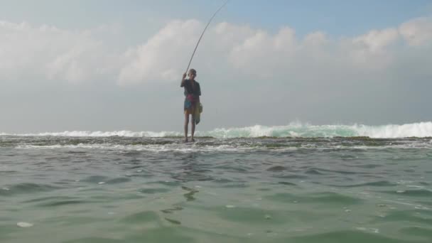 Silueta de pescador envejecido se encuentra en aguas profundas del océano azul — Vídeo de stock