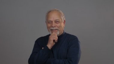 Düşünceli yaşlı adam başını sallar ve el ele konuşur.