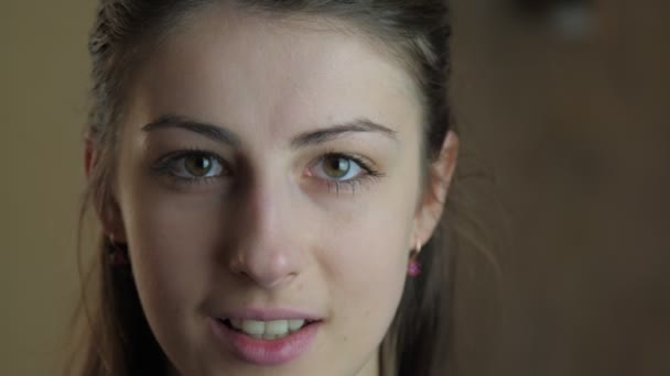 Bruin ogen brunette met gouden oorbellen glimlacht vrolijk — Stockvideo