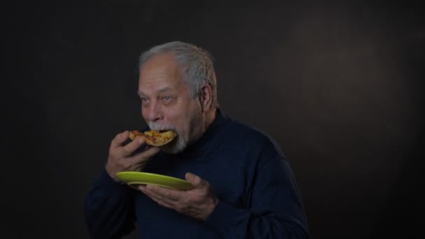 Ευτυχής συνταξιούχος μασά πίτσα κρατώντας πράσινο πιάτο στο χέρι — Αρχείο Βίντεο