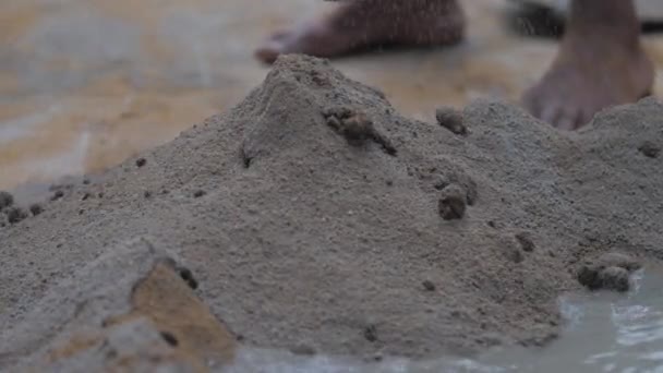 Pessoa mistura cimento e água em movimento com pá de metal — Vídeo de Stock