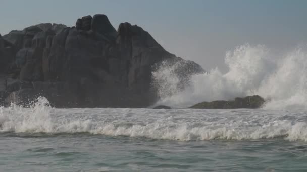 Tunga havsvågor slår på grå klippor nära tropiska kusten — Stockvideo
