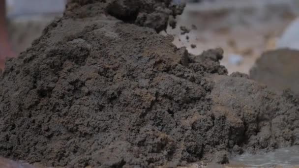 Person blandar våt cement med metallspade på marken — Stockvideo