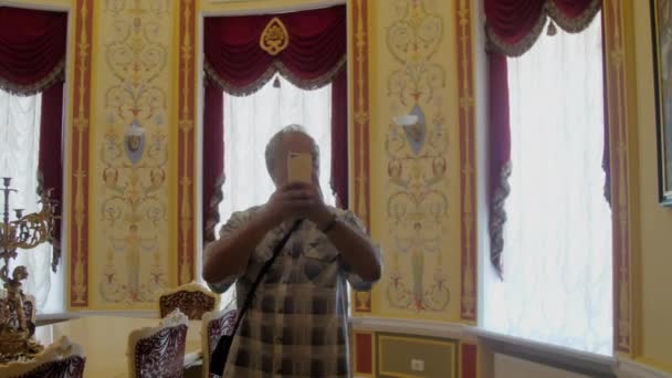 Gepensioneerde met snor maakt foto 's van prachtige museumkamer — Stockvideo