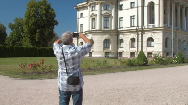 老人手持智能手机与庄园博物馆对决 — 图库视频影像