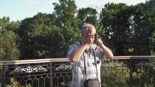 Vecchio cammina vicino ringhiera in metallo contro la natura verde lussureggiante — Video Stock