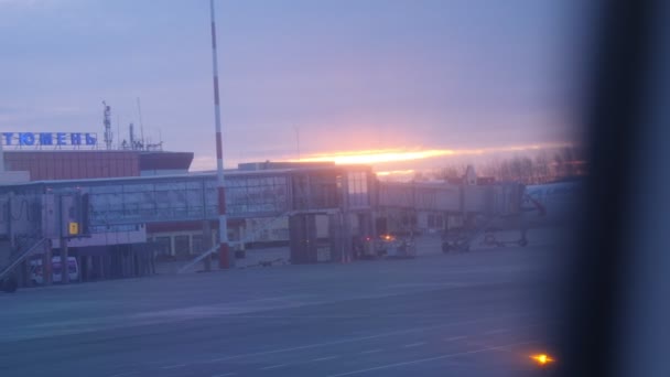 Nascer do sol contra o terminal do aeroporto com corredor telescópico — Vídeo de Stock