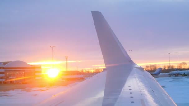 Airplane wing moves during aircraft taxiing against sunrise — Stock Video