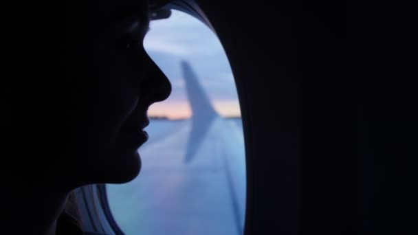 Senhora agradável senta-se no assento da janela e observa asa da aeronave — Vídeo de Stock
