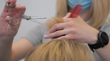 Bayan tek kullanımlık tarak tutuyor ve modern saç stili uyguluyor.