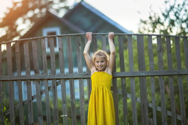 Meisje speelt in de buurt van dorpswoningen — Stockfoto