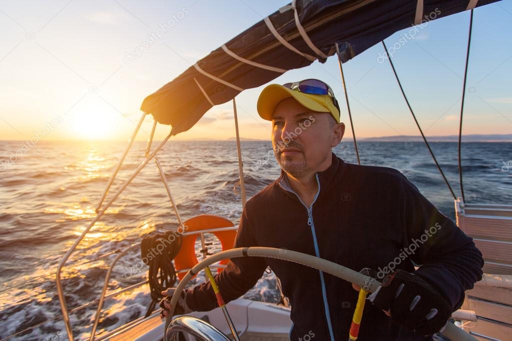 Skipper drives the sailing boat Stock Photo by ©dimaberkut 125757260