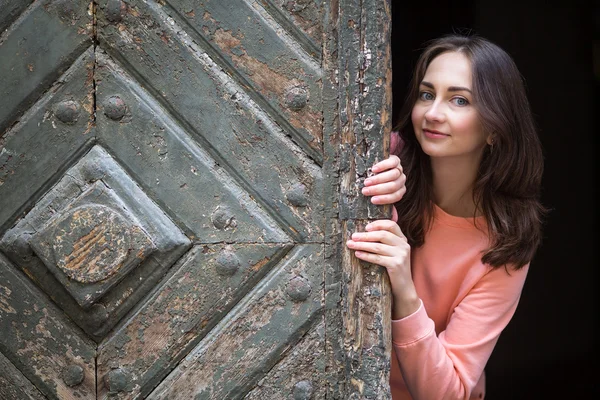 Mignonne fille jette un coup d'oeil dehors de portes — Photo