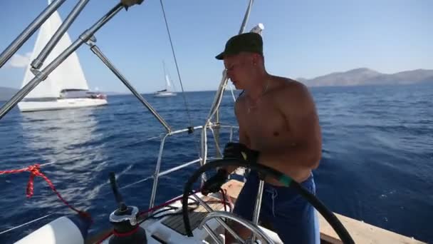 Yachtsman durante la carrera, en su yaht barco de vela en el mar . — Vídeo de stock