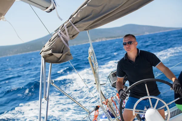 Junger Skipper steuert Boot — Stockfoto