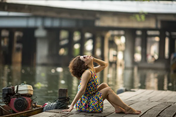 Femme assise sur un quai de rivière — Photo