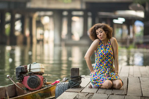 川のドックに座っている女性 — ストック写真