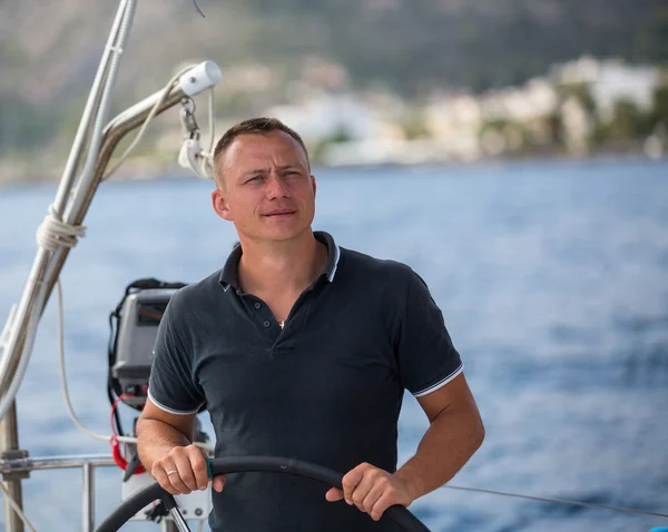 Man steering sailing yacht — Stockfoto