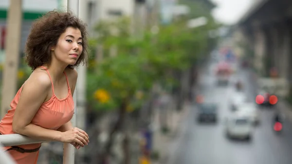 Asiatisk kvinna i en suddig stadslandskap — Stockfoto