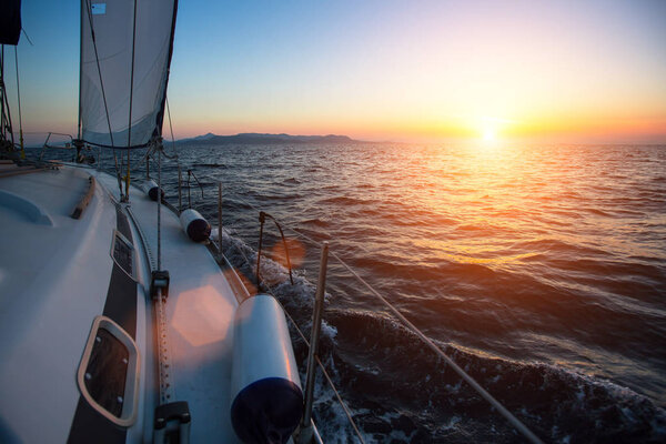 Yacht sailing against sunset