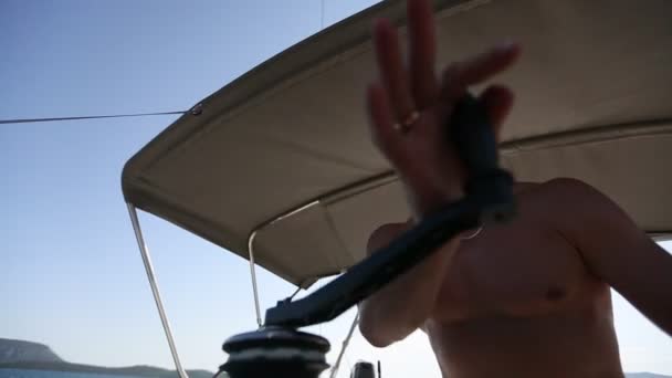 Человек-шкипер на яхте тянет веревку — стоковое видео