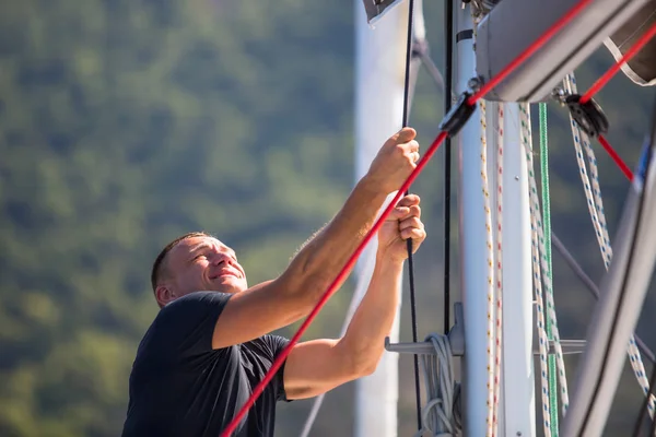 Uomo tirando corde a yacht — Foto Stock