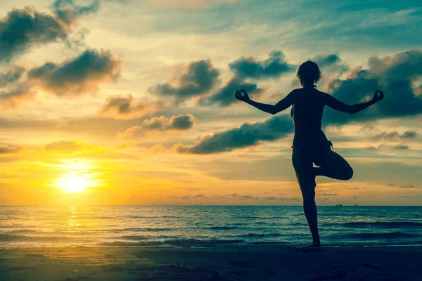 Vrouw beoefenen van yoga aan de kust — Stockfoto