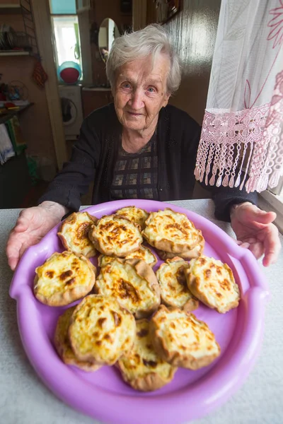 Ältere Frau mit selbstgebackenem Kuchen — Stockfoto