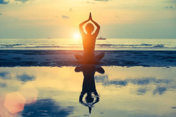 Silhouette of woman doing yoga at sunset — Stock Photo, Image