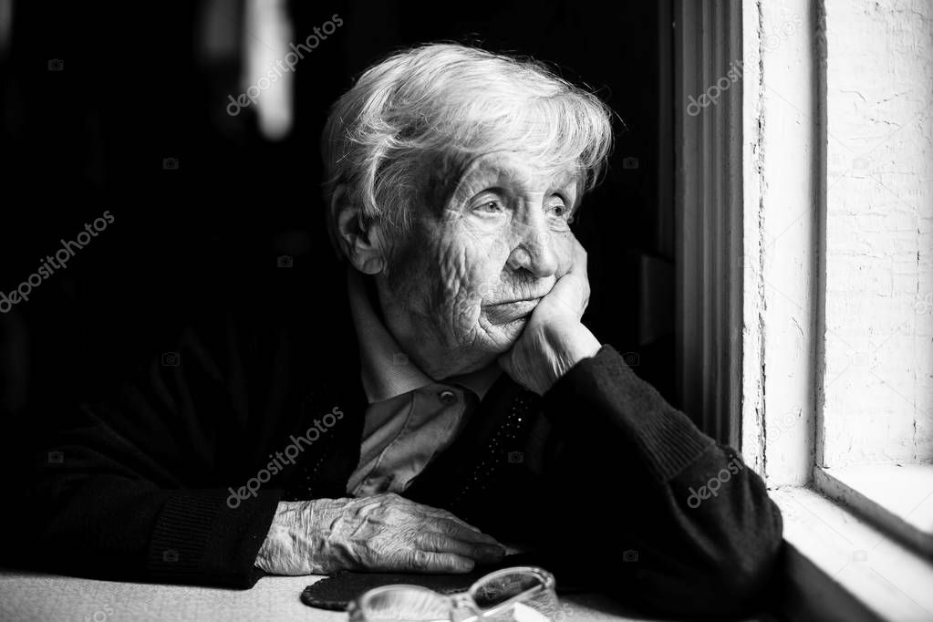 Elderly woman looking out the window