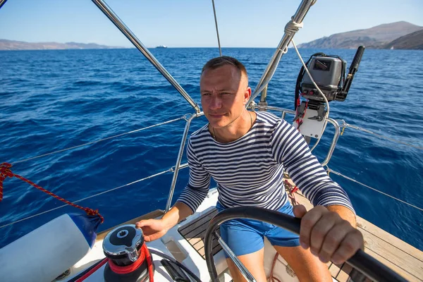 Homme à la barre de son yacht — Photo