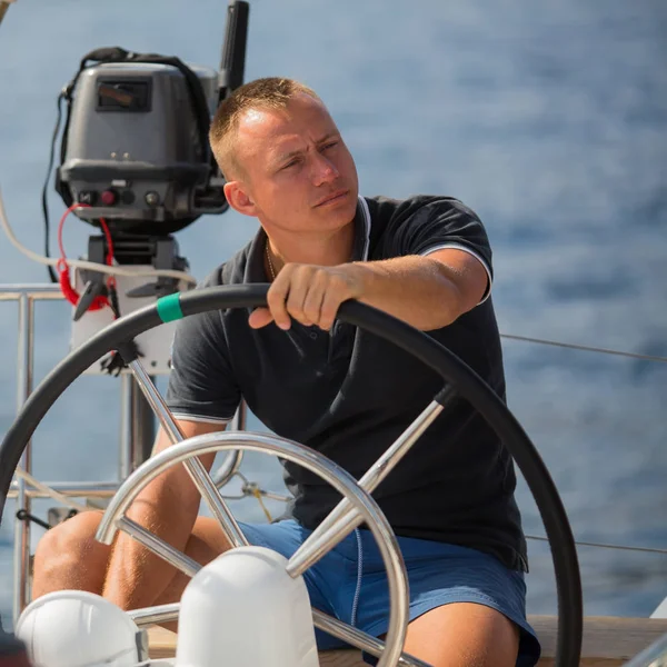 El hombre se sienta al timón en el barco —  Fotos de Stock