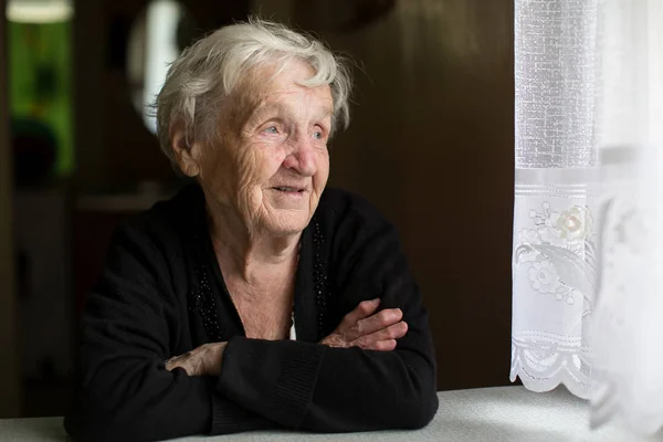 Пожилая женщина смотрит в окно — стоковое фото