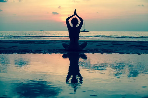 Silhueta de mulher praticando Yoga — Fotografia de Stock