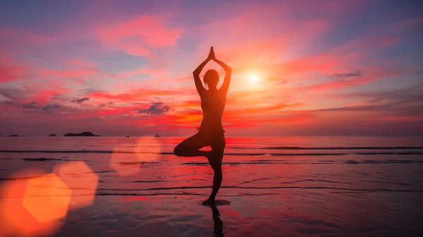 Chica de la meditación en el mar durante la puesta del sol — Foto de Stock