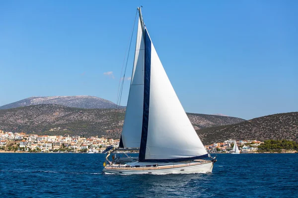 Boot mit weißen Segeln im Meer — Stockfoto