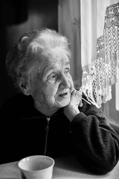 elderly woman with tea at a table