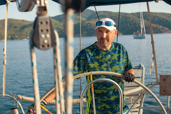 Marinheiro no leme de seu iate à vela — Fotografia de Stock