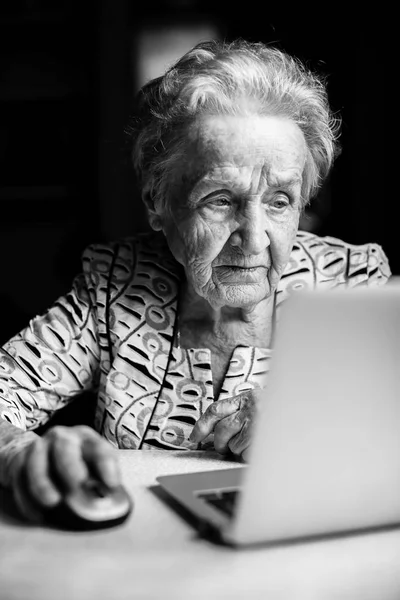 Mulher idosa sentada à mesa — Fotografia de Stock