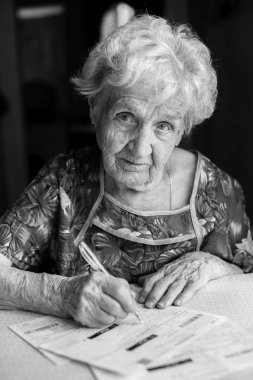 Yaşlı kadın yardımcı programları için okundu bilgisi doldurur