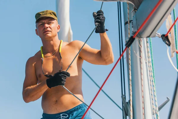 Knappe man op zeilboot. — Stockfoto