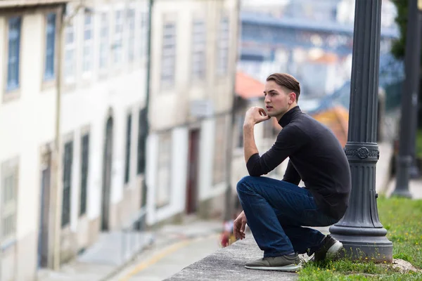 Ung man squating i gränd — Stockfoto