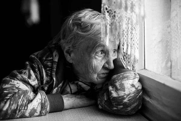 Woman looking wistfully out window — Stock Photo, Image